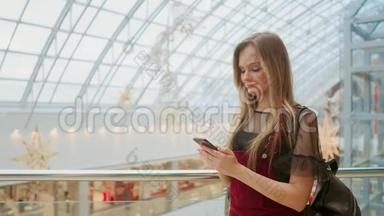 女孩使用手机，模糊的形象内商城作为背景。